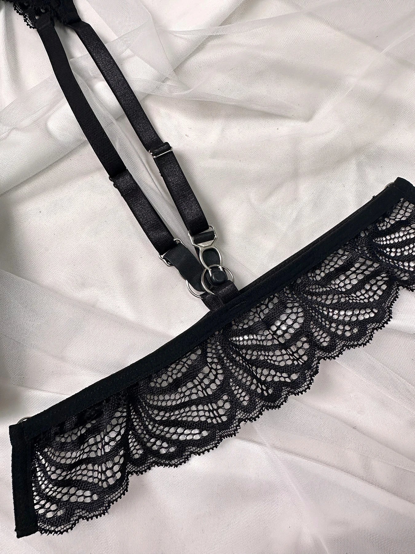 Elegant black lace lingerie set with strappy bra, garter belt and thong with floral details
